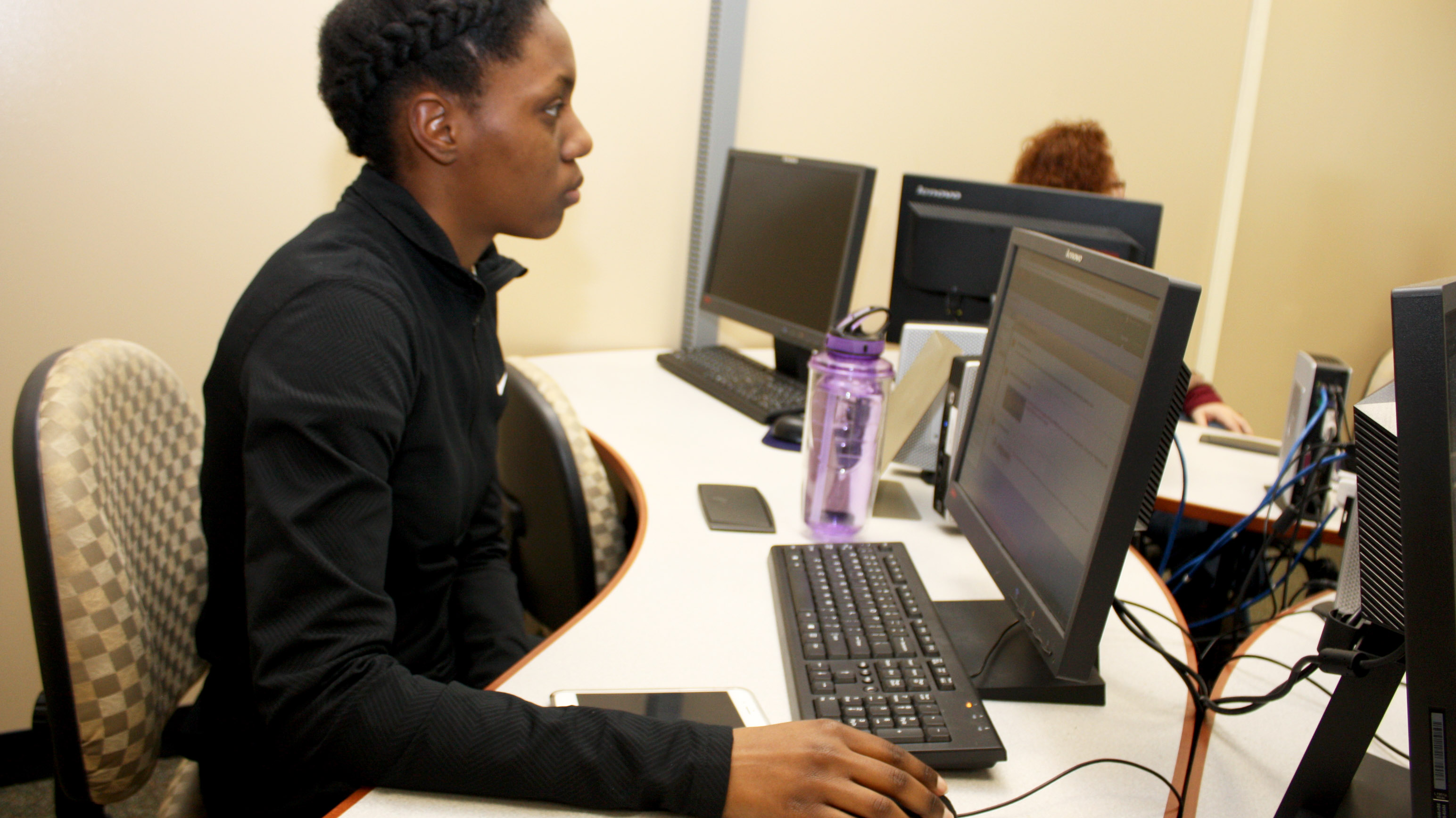 A female student in front of a computer.