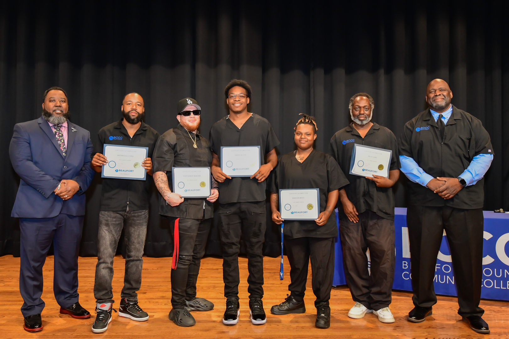 a group of people dressed in black with certificates