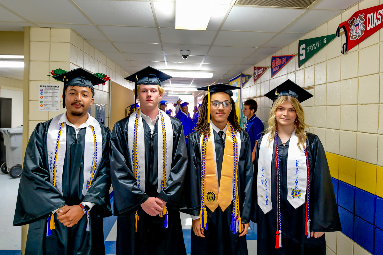 four students in graduation robes