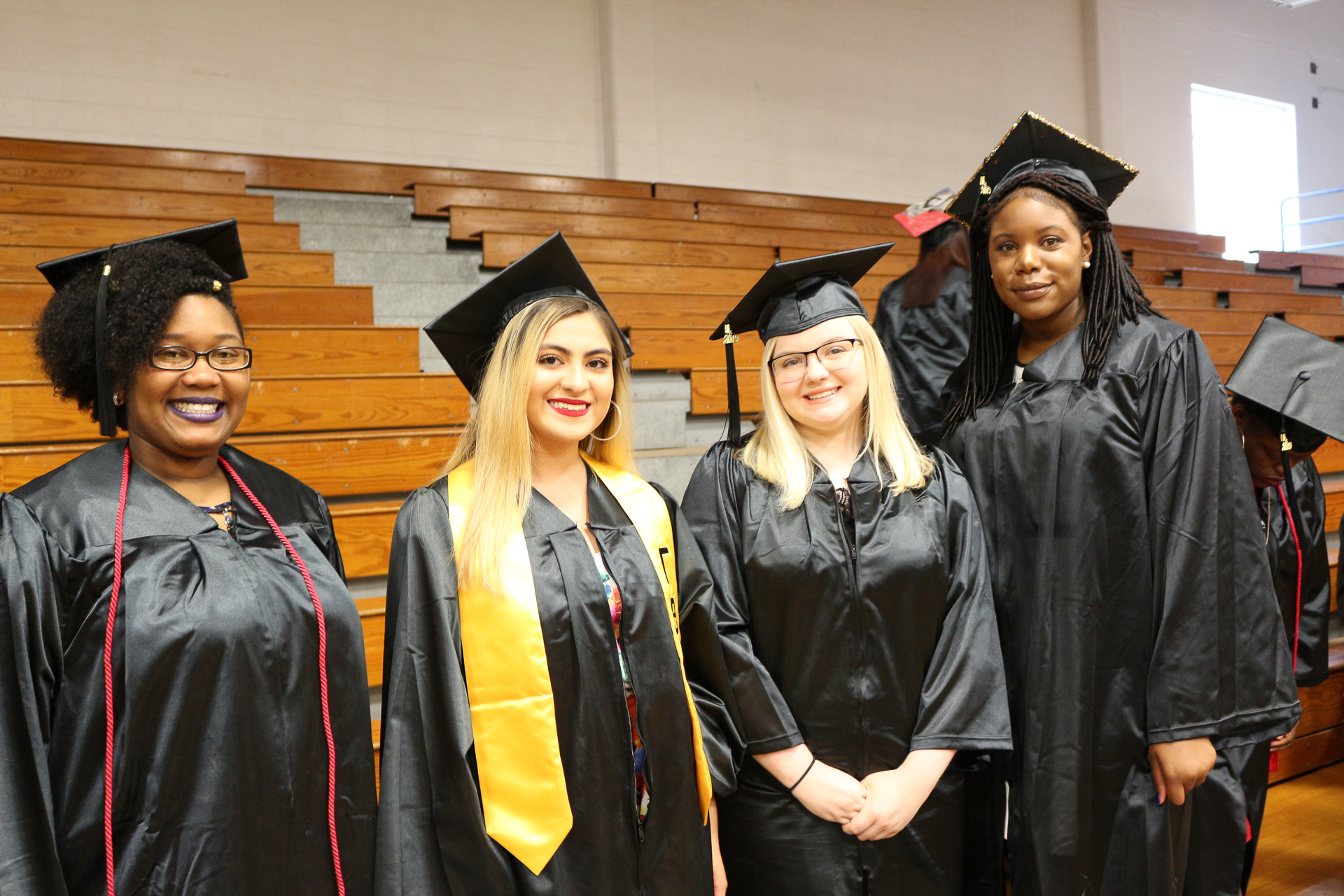 four students in cap and gowns