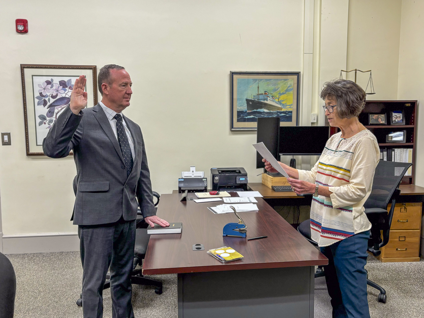 a person in a suit hand up getting sworn in