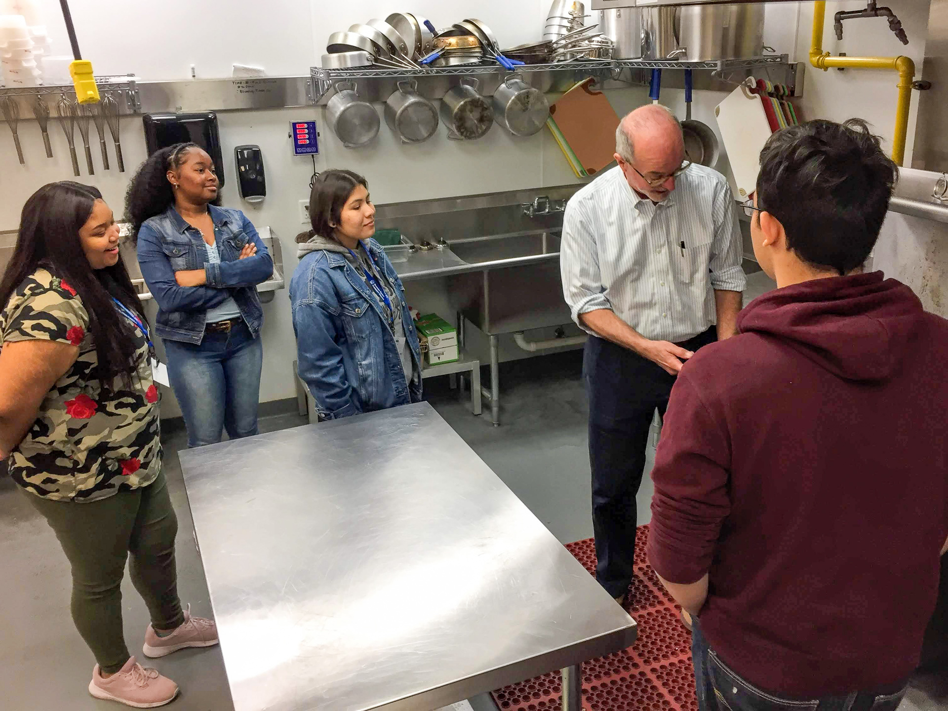 A group of students in a kitchen with an instructor.